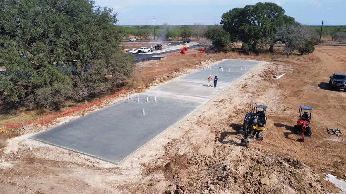 Construction site with concrete foundation and machinery.