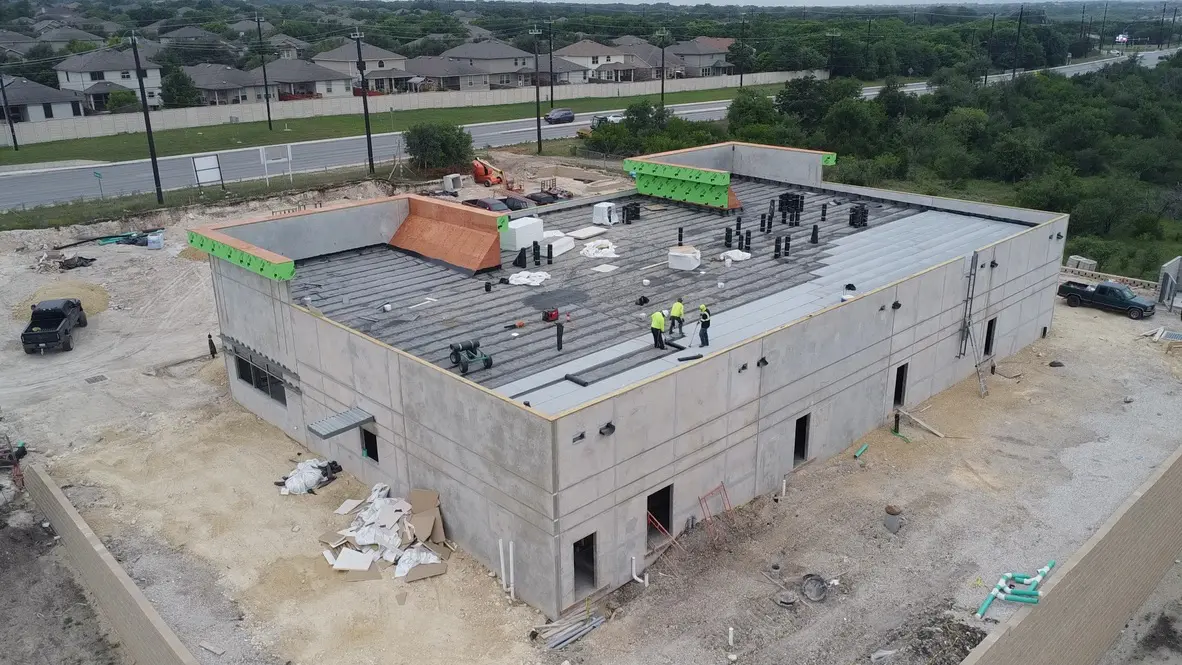 Construction site with workers on building roof.