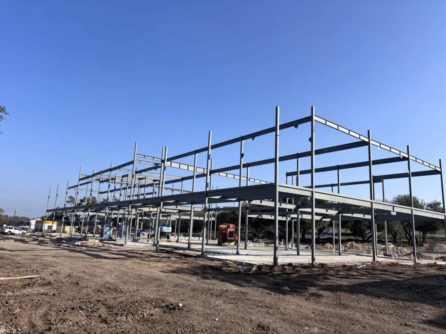 Steel construction framework under clear blue sky.
